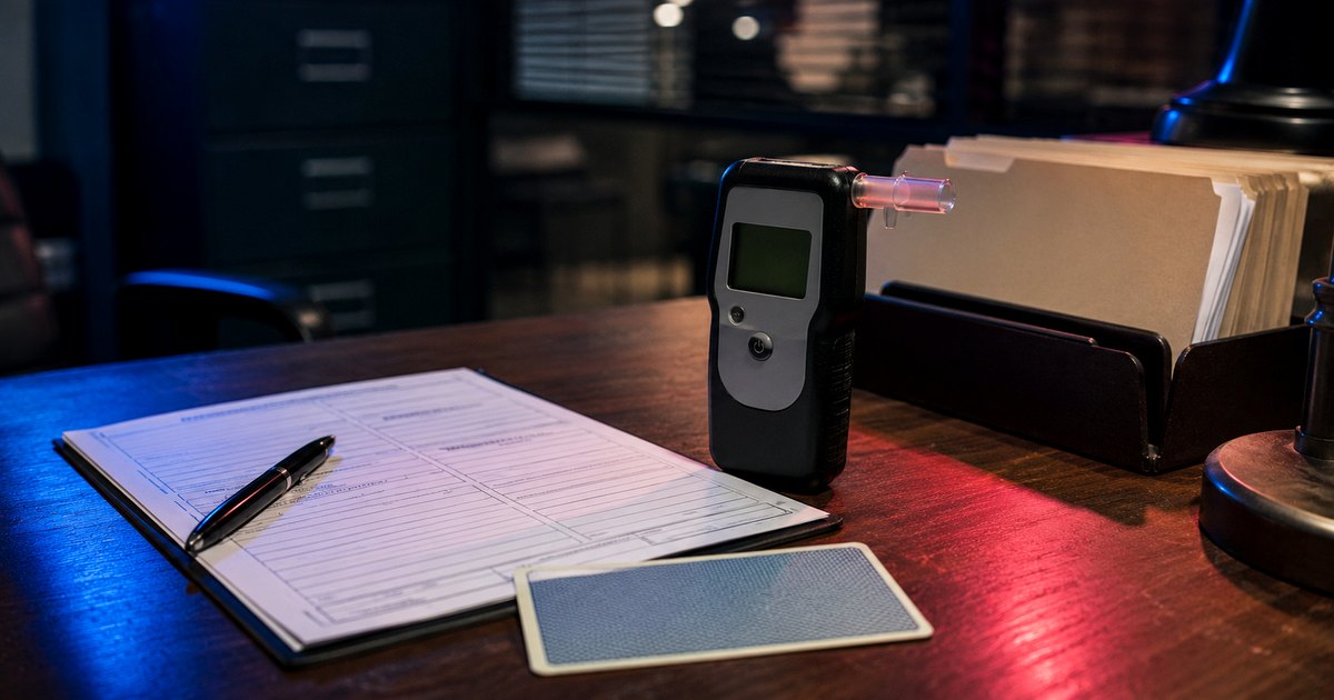 Breath testing device beside DUI paperwork on a legal office desk